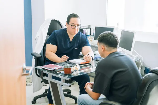 Dr. Erick Vargas en consulta de cirugía general con un paciente en Ciudad Juárez